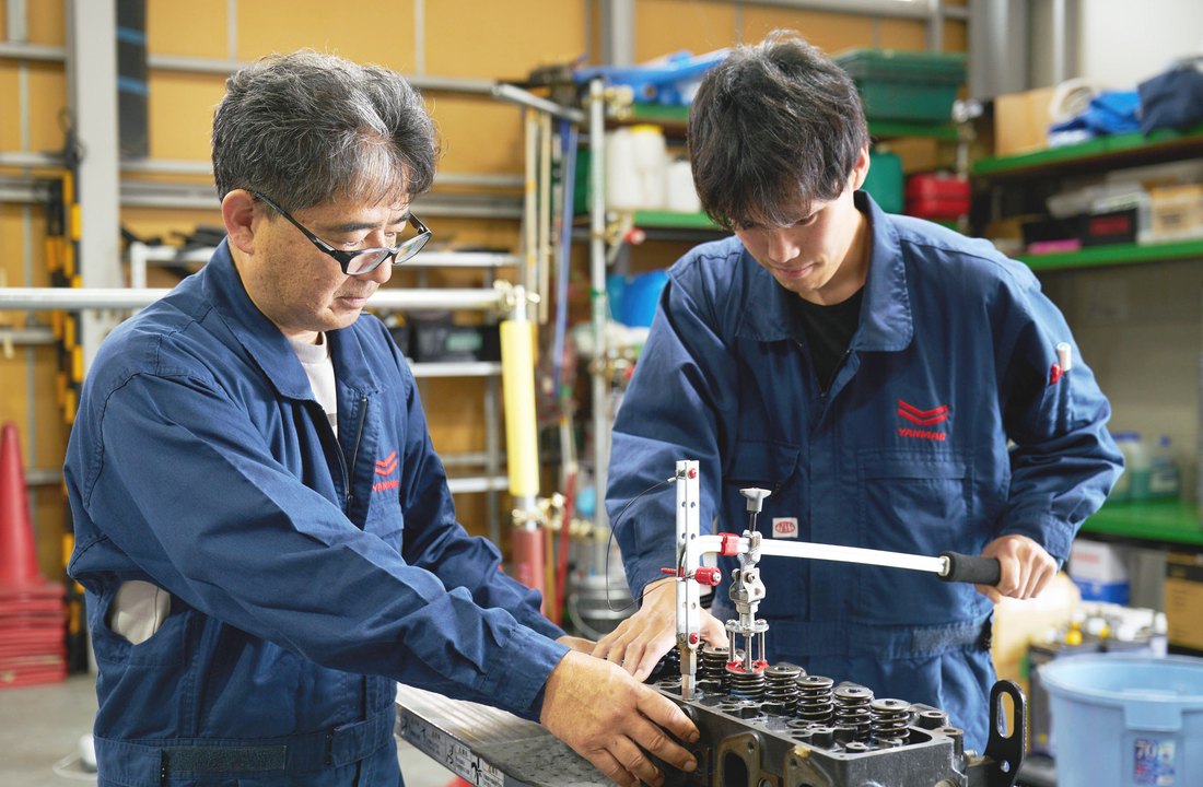先輩社員が若手社員をフォローしながら作業する様子