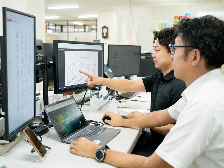 本社でモニターを見ながら仕様確認を行う営業スタッフ
